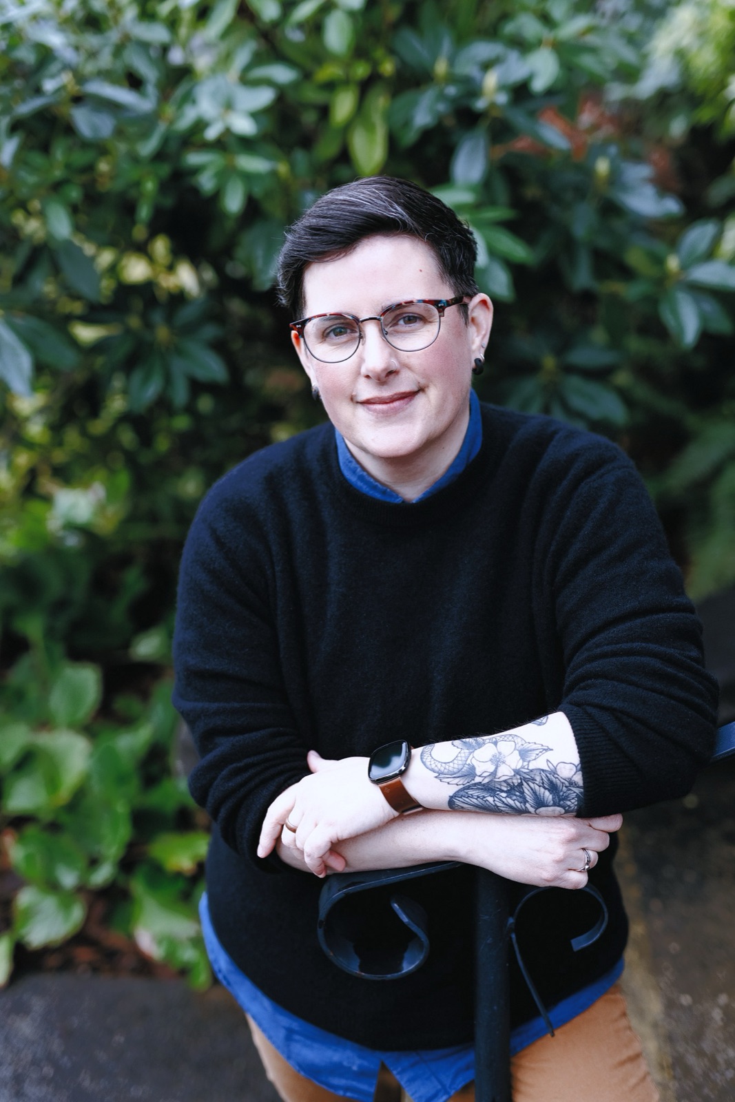 Morgan Brooks smiling at the camera, wearing glasses and a black sweater